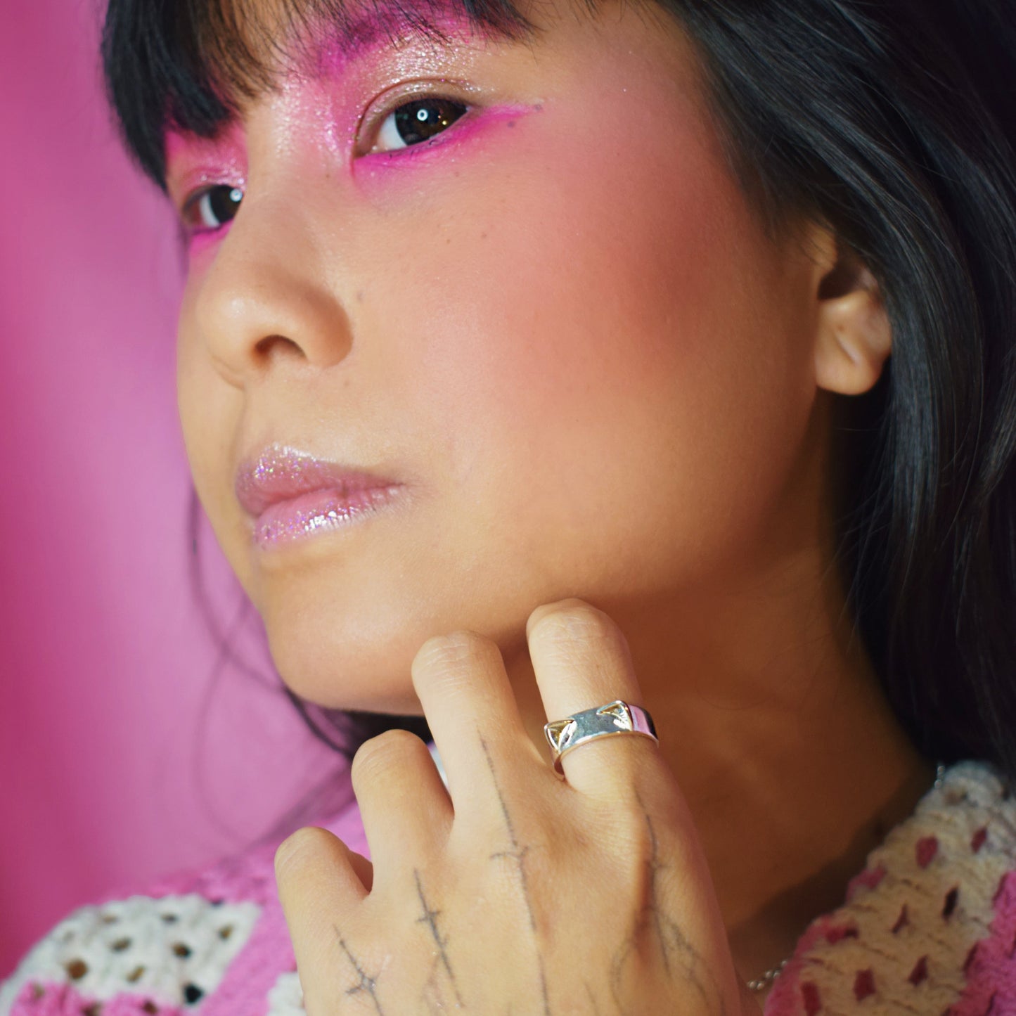 Person with colorful makeup and a pink background